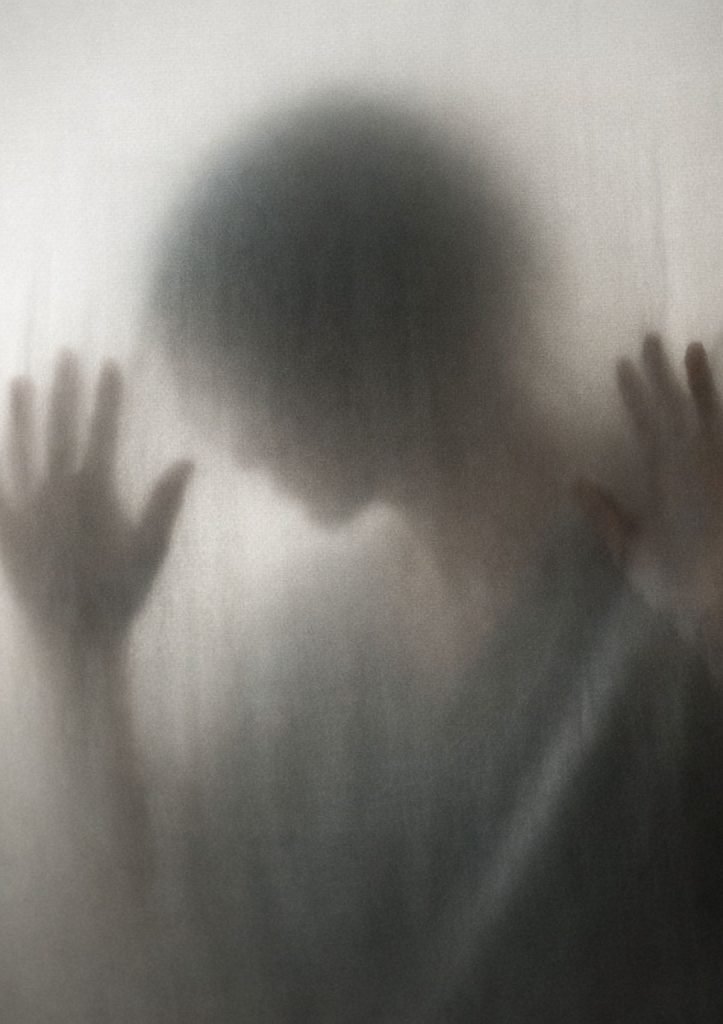 Silhouette floue derrière un voile symbolisant une situation d’emprise psychologique